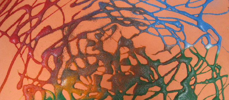 Glittery multicolored paint swirls on an orange background
